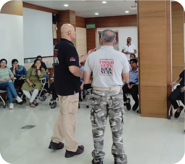 Instructor demonstrating self-defence techniques to participants in a training room